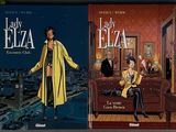 two books of lady elza and elza, one of which is sitting on a couch and the other