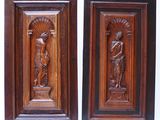 pair of carved wood plaques depicting a woman and a man