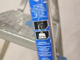 a close up of a metal ladder with a sticker on it