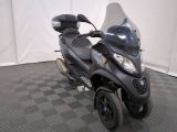un scooter garé sur un sol à damier