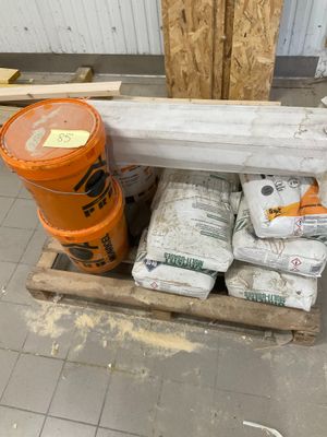 une palette de ciment et un seau de ciment posé sur une palette