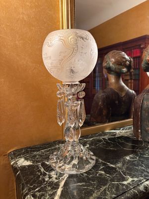 un vase en verre posé sur une table en marbre à côté d'un miroir
