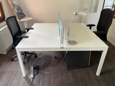 a white desk with a laptop on it and a black chair