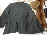 a coat, hat, purse, and other items laid out on a table