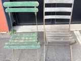 two chairs sitting next to each other on the sidewalk