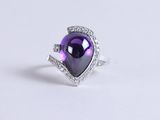 a close up of a purple heart shaped ring with diamonds on a white surface