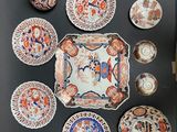 many plates and cups on a table with a teapot
