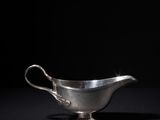 a silver gravy on a black background