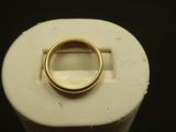 une bague en or posée sur un objet blanc