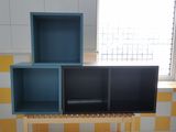 a blue and yellow shelf in a bathroom next to a window