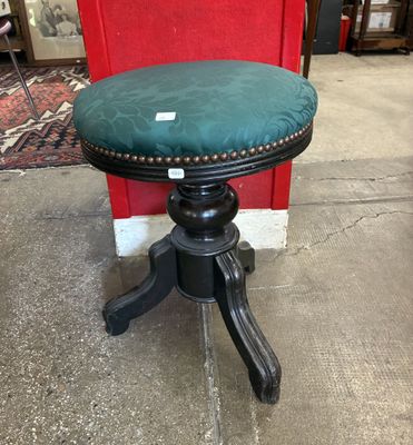 une image représentant un tabouret noir surmonté d'un coussin vert