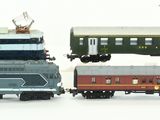 four toy trains sitting next to each other on a white surface