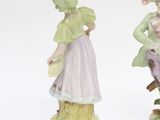 two figurines of people standing next to each other