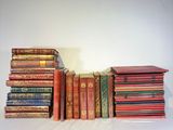 a lot of books stacked on top of each other on a table