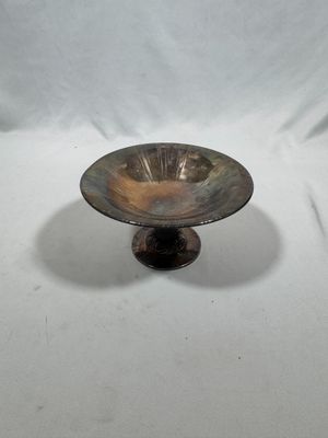 a small metal bowl on a stand on a white background