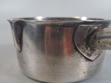 a silver cup with a handle on a white table