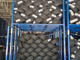 a large stack of tires in a warehouse with pallets