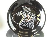a black and white plate with a fish on it