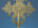 gold metal cross on a table with a blue background
