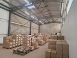 un grand entrepôt rempli de cartons et de palettes