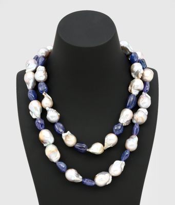 un collier de perles blanches et bleues sur un mannequin noir