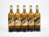 quatre bouteilles de vin sont alignées sur une surface blanche