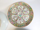 a plate with a floral design on it next to a plate with a flower design on it