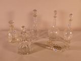 five glass bottles sitting on a table with a chain around them
