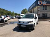 une camionnette blanche garée devant un bâtiment dans un parking