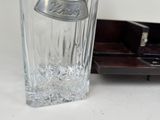 a glass vase with a silver lid sitting on a table