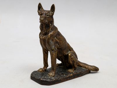 une image représentant une statue en bronze d'un chien assis sur un socle