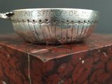a silver bowl sitting on top of a red marble block