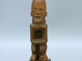une petite statue en bois représentant un bébé tenant un livre