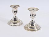 pair of silver candlesticks on a white background