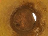 a close up of a yellow vase with a hole in it