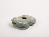 an image of a small green stone object on a white surface