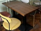 des tables et des chaises dans une pièce avec un parquet et des murs verts