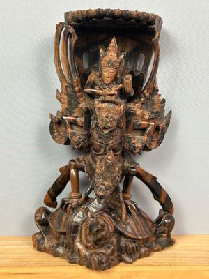 une photo représentant une statue d'une personne posée sur une table en bois