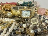 a pile of jewelry that includes a watch, bracelets, and other items