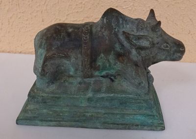 bronze statue of a cow with a harness on it ' s back