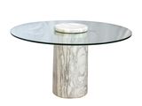 La table est en marbre et possède un plateau en verre.