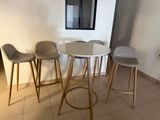 three stools and a table in the corner of a room