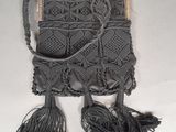 an image of a black purse with tassels hanging from it