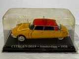 a yellow toy car in a glass case on a white surface