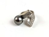 bague en argent avec une perle noire et des diamants sur fond blanc