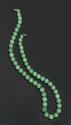 un collier de perles de jade vert et une paire de boucles d'oreilles