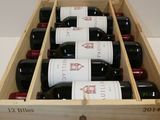 bottles of red wine in a wooden box on a table