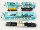 Plusieurs petits trains jouets sont posés les uns à côté des autres sur une surface blanche