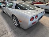 a silver sports car parked in a garage with other cars