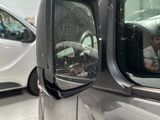 a reflection of a man in the side view mirror of a car